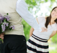 Mann berrascht Frau mit Blumenstrauss