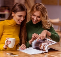 Zwei Frauen schauen einen Katalog an.