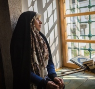 Verschleierte Frau sitzt am Fenster 