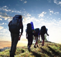 Wanderer laufen hintereinander auf einem Grat