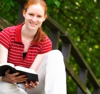 Frau liest Bibel in der Natur