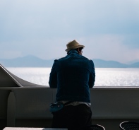 Mann auf Boot schaut auf Wasser