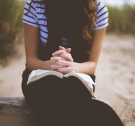 Frau mit Bibel auf dem Schoss (Symbolbild)