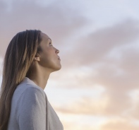 Frau schaut zum Himmel empor