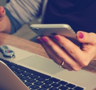 Frau mit Smartphone und Laptop